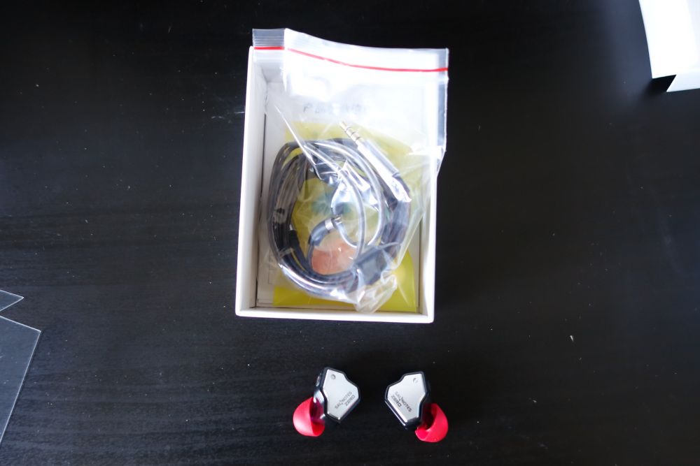 The buds with the gross red tips and the cable in the box